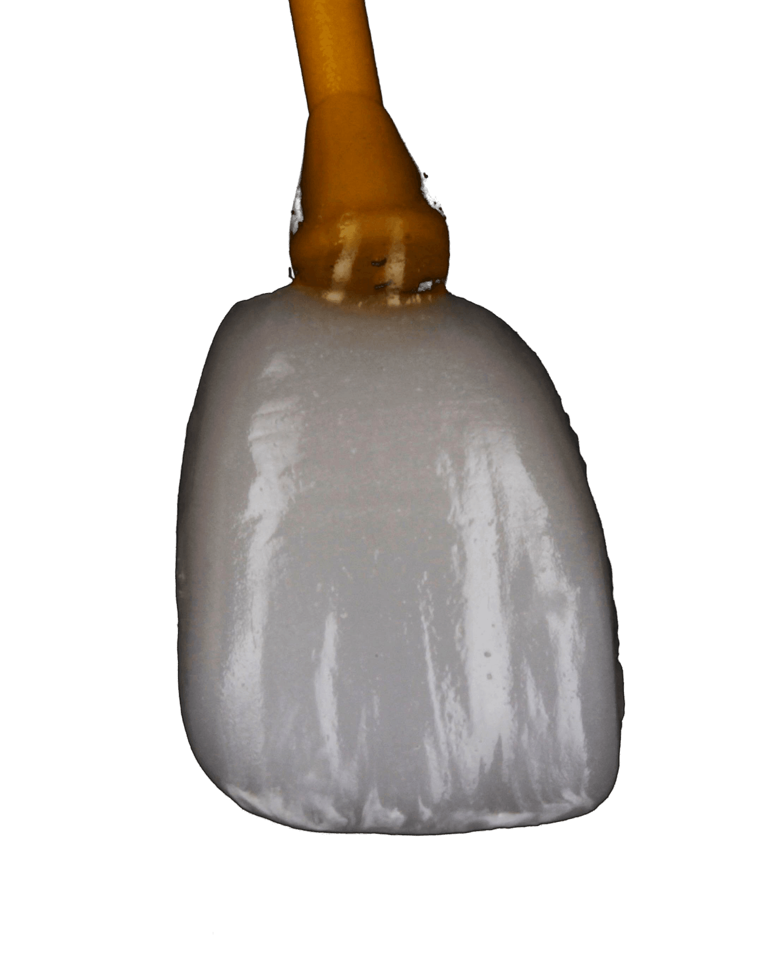 Close-up of a hand-finished E.max porcelain veneer on its modelling stick, showing the layered surface texture and the translucency of the fired ceramic.